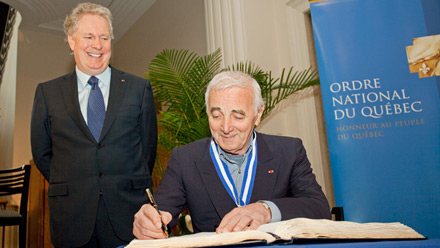 Charles Aznavour, O.Q., témoigne de son amour pour le Québec, sous le sourire approbateur du premier ministre.