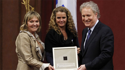 Le premier ministre, M. Jean Charest, et la prsidente du Conseil de l'Ordre national du Qubec, Mme Maryse Lassonde, C.Q., recevant de l'astronaute Julie Payette, C.Q., la microplaquette sur laquelle le nom des membres de l'Ordre national est inscrit  l'chelle nanomtrique.