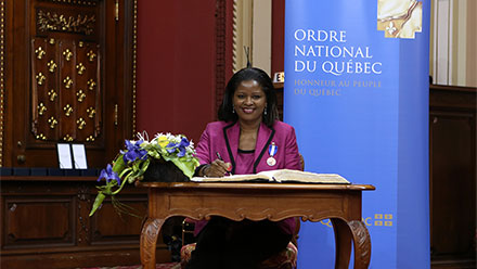 Amina Gerba, C.Q., fière de signer le livre d’or. Photo : François Nadeau