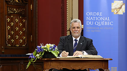La signature du livre d’or, par le premier ministre. Photo : François Nadeau